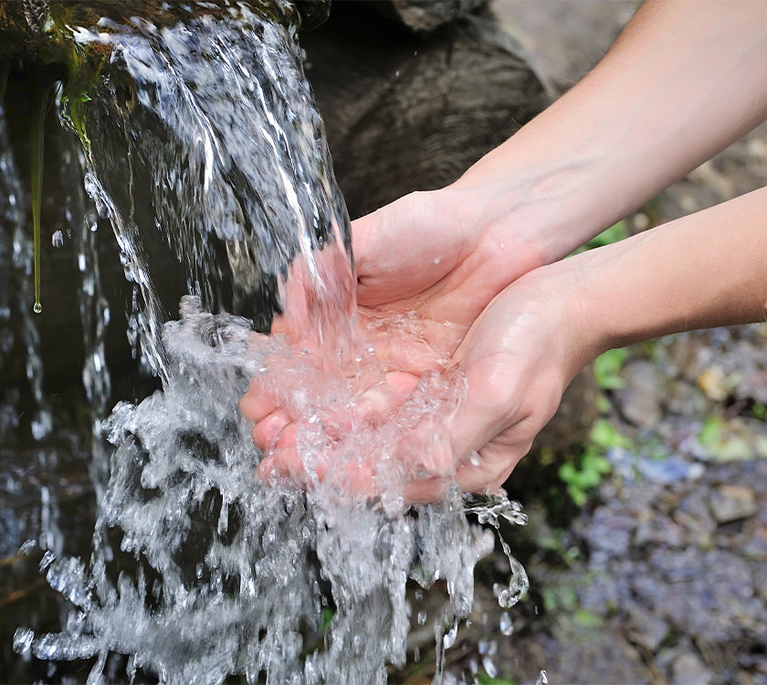 Someone washing their hands in a natural spring